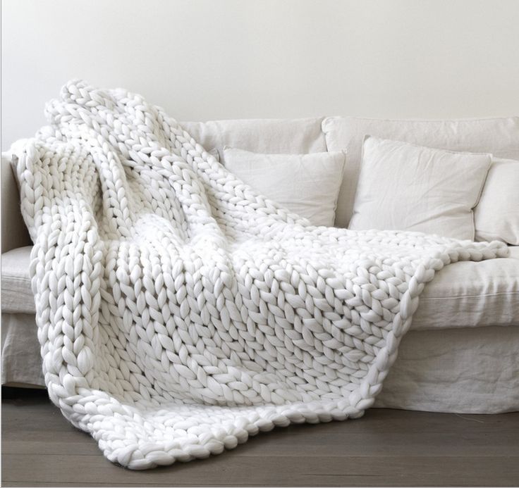 a white blanket sitting on top of a couch