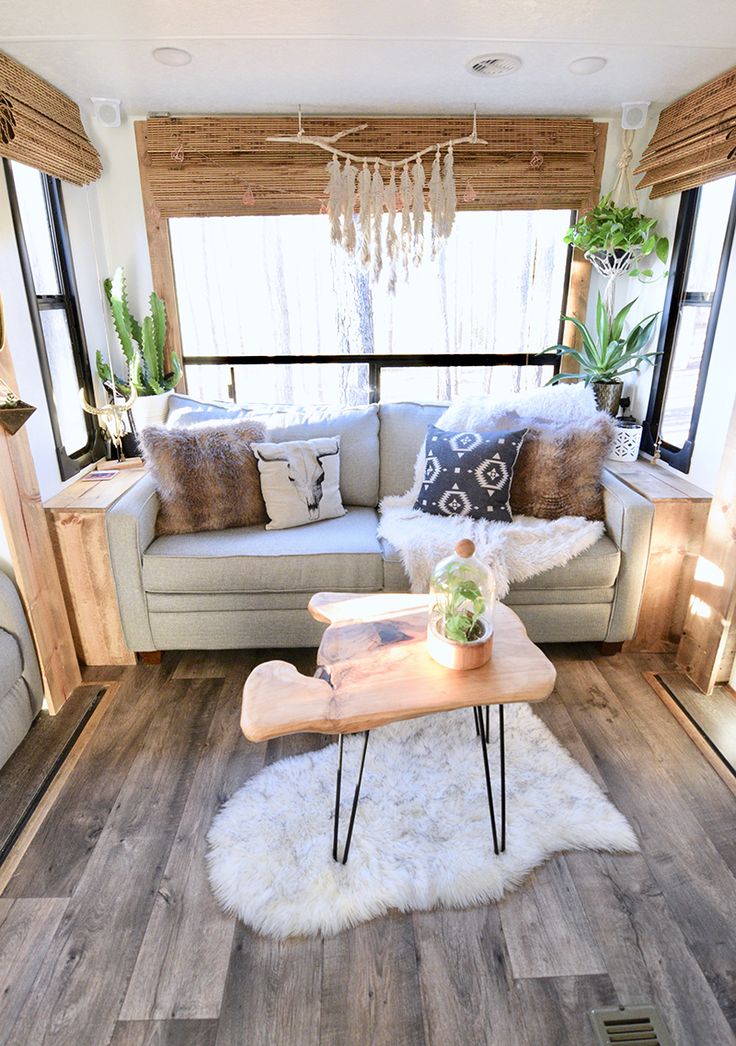 a living room filled with furniture and lots of pillows on top of a wooden table