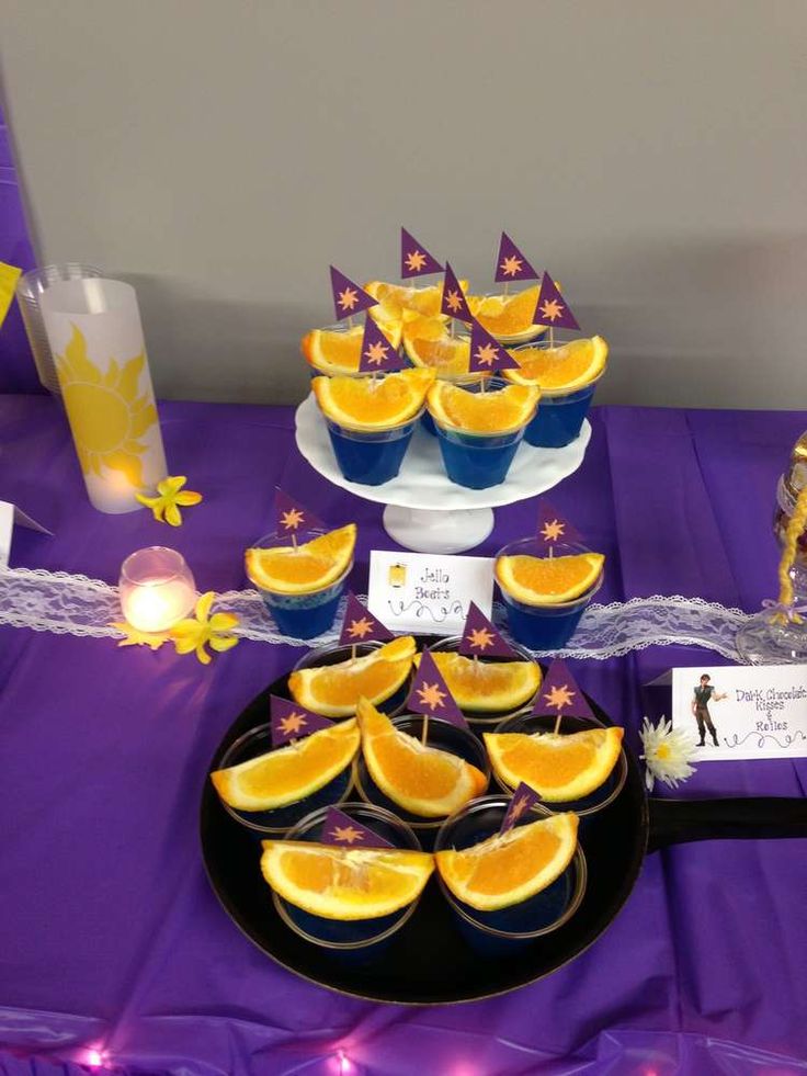 a table topped with orange slices and cupcakes