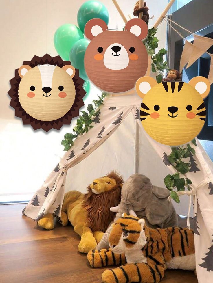 several stuffed animals are sitting in front of a teepee tent with decorations on it