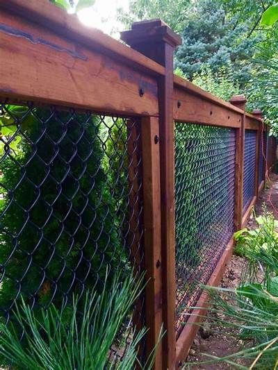 a wooden fence surrounded by plants and trees