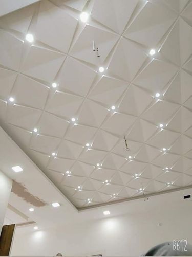 an empty room with white walls and ceiling tiles on the ceiling is lit by lights