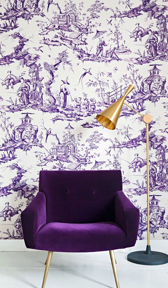 a purple chair sitting in front of a white wall