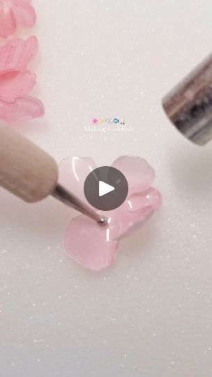 a pink flower is being used to paint the petals on a white surface with a brush