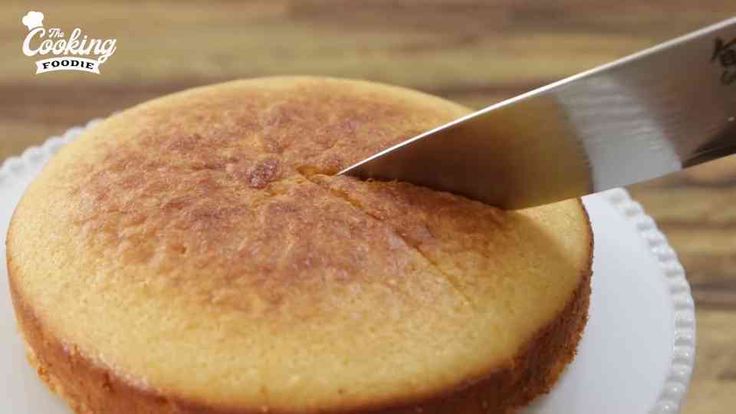 a person cutting into a cupcake with a large knife on the top of it