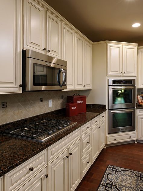 a large kitchen with white cabinets and granite counter tops, along with an area rug on the floor