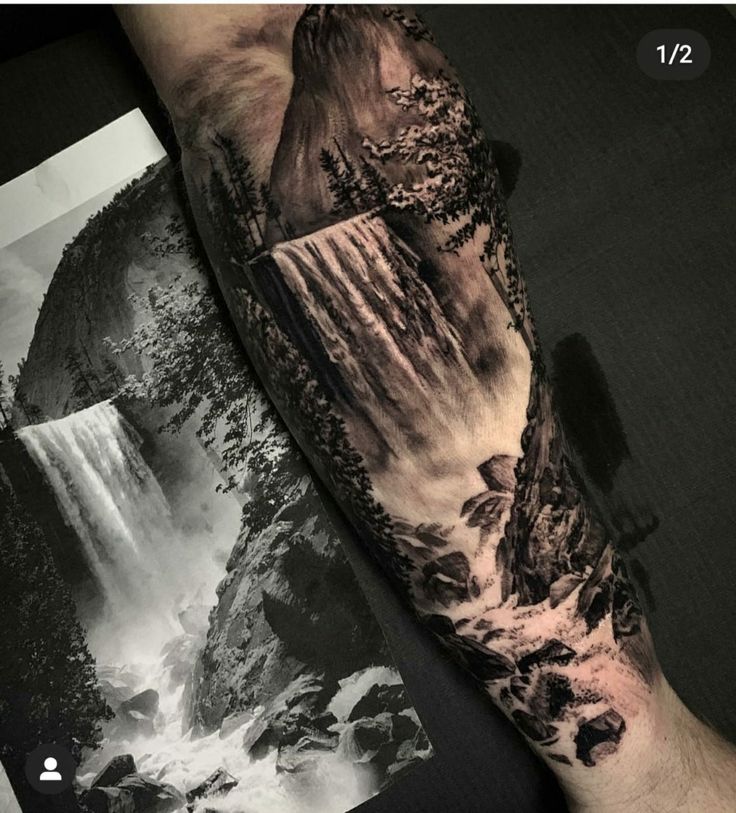 a man's arm with a waterfall and trees on it