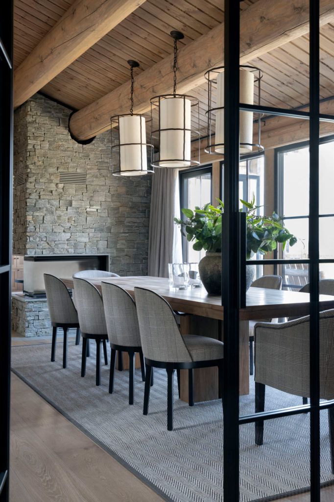 the dining room table is surrounded by gray chairs and large vase with flowers on it