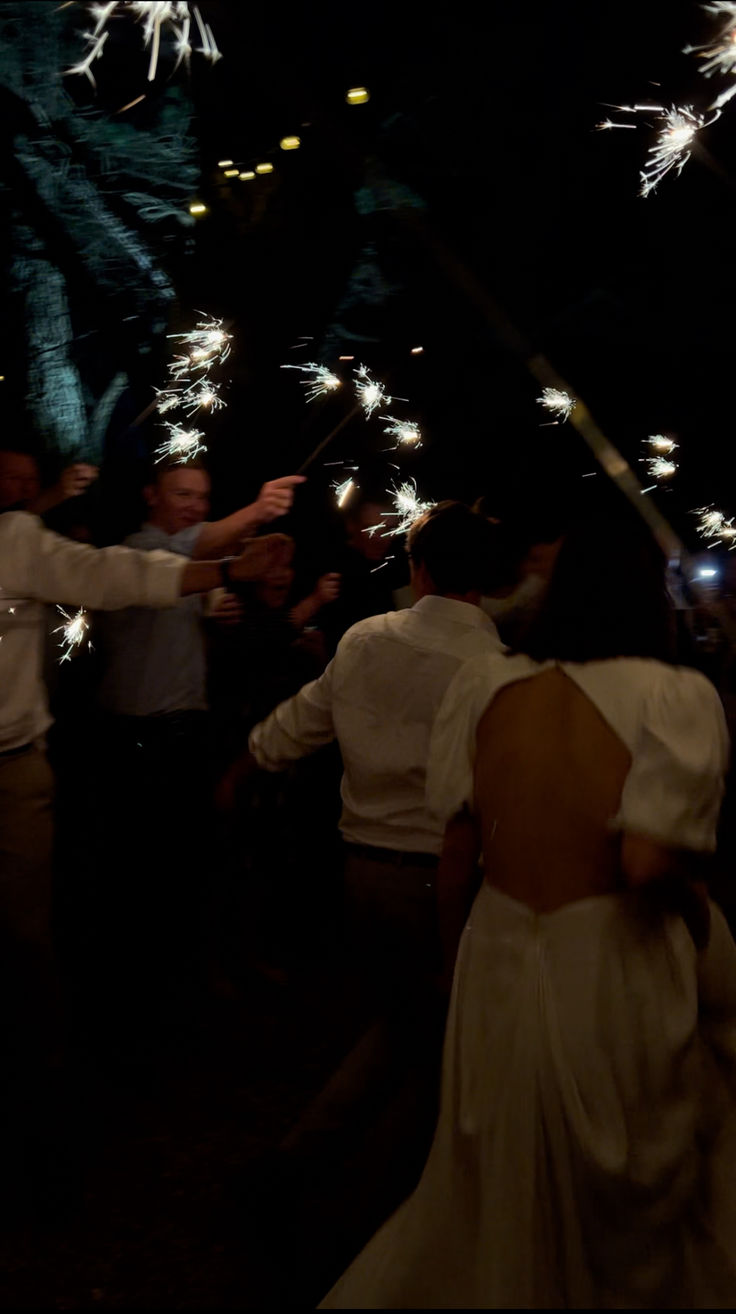 the bride and groom are surrounded by sparklers