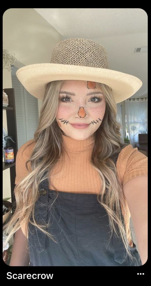 a woman wearing a hat with cat's face painted on it