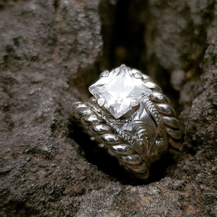 a silver ring sitting on top of a rock