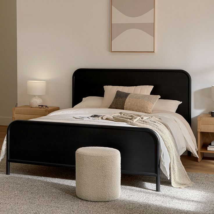 a bedroom with a bed, night stand and two nightstands on either side of the bed