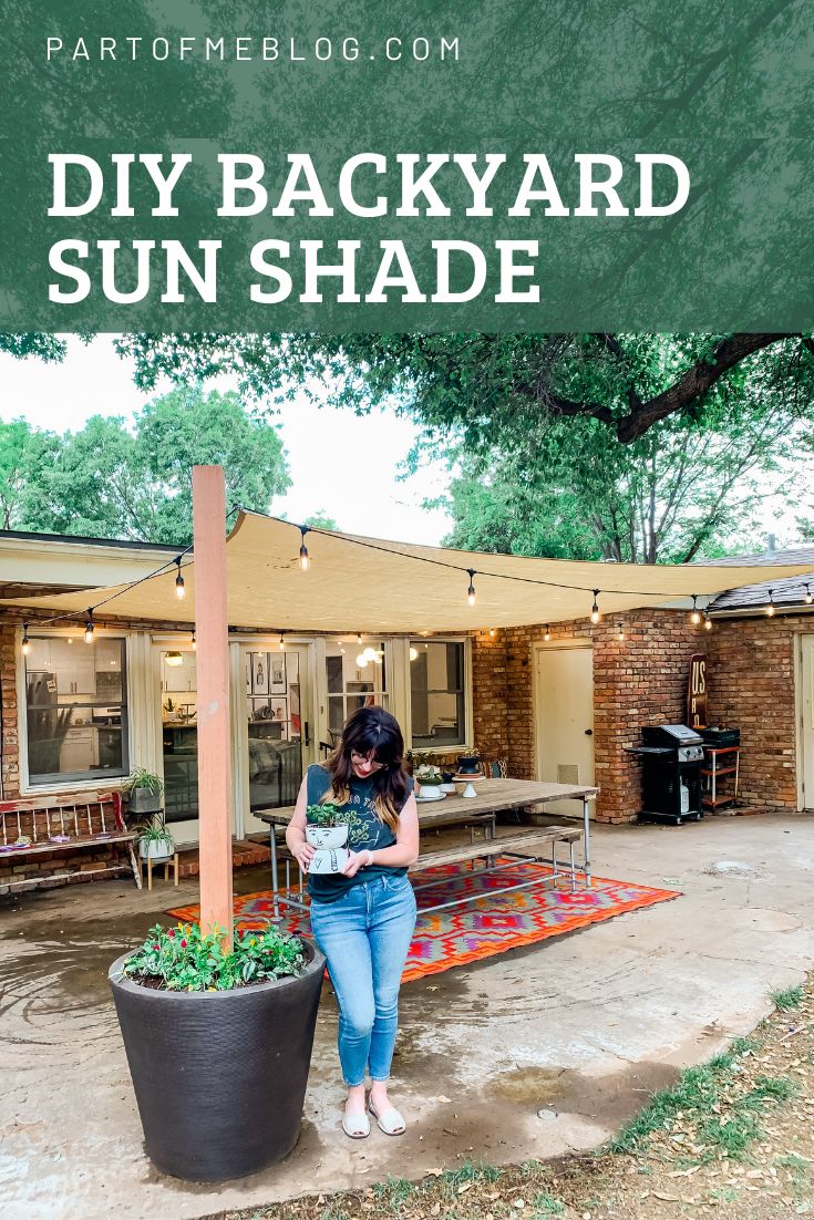 a woman standing next to a potted plant in front of a house on a patio