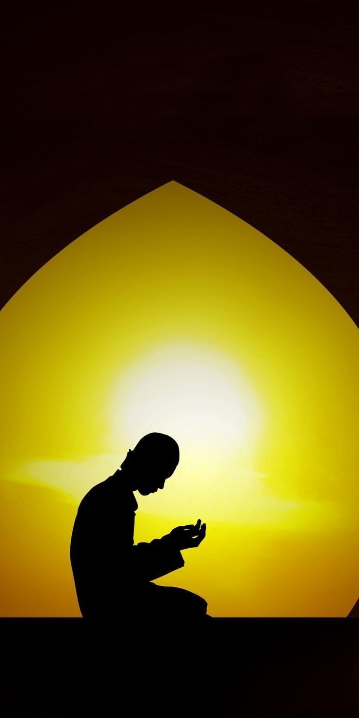 the silhouette of a person kneeling in front of a sunset