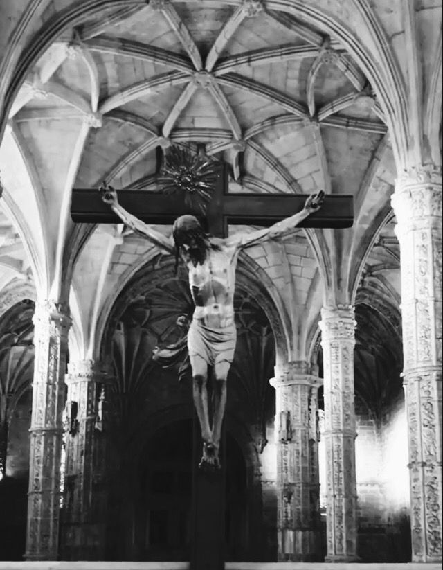 black and white photograph of jesus on the cross in an old church with vaulted ceilings