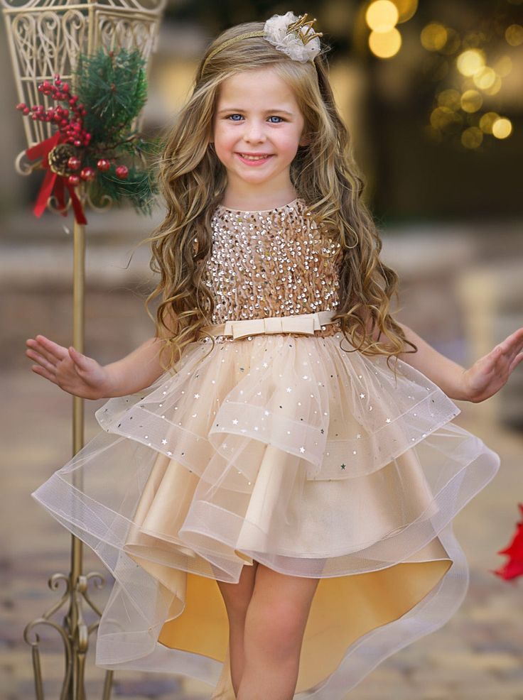 Little princesses NEED this sequined hi-lo tutu dress! This twirl-worthy showstopper features an extra sparkly bodice, a voluminous layered skirt, and a charming belt accent. Glitter and glam all around! 	Elegant design makes a sophisticated style statement. Guaranteed to make your princess look and feel extra special. 	Fully lined skirt gives her the confidence and coverage to move, play, and pose without worry. 	Perfect for weddings, formal events, special occasions, birthday parties, photoshoots, and more 	Sequin-embellished tutu dress with asymmetrical layered skirt and belt detail Glamorous Festive Tulle Dress, Glamorous Tulle Dress For Festive Occasions, Holiday Princess Tutu Dress With Sequins, Holiday Princess Sequined Tutu Dress, Spring Pageant Sequin Tutu Dress, Spring Sequined Tutu Dress For Pageant, Party Season Sequined Tutu Dress With Glitter Tulle, Sequin Glitter Tulle Tutu Dress For Prom, Prom Tutu Dress In Glitter Tulle With Sequins