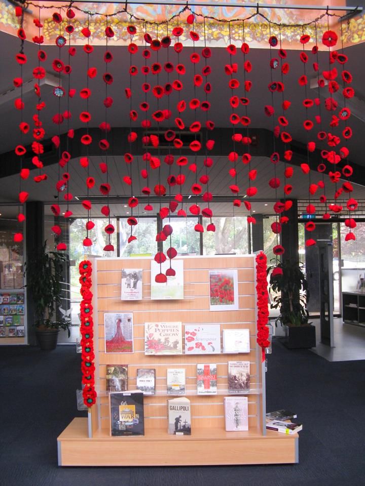 a display case with red flowers hanging from it's ceiling