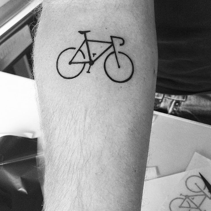 a black and white photo of a man's arm with a bicycle tattoo on it