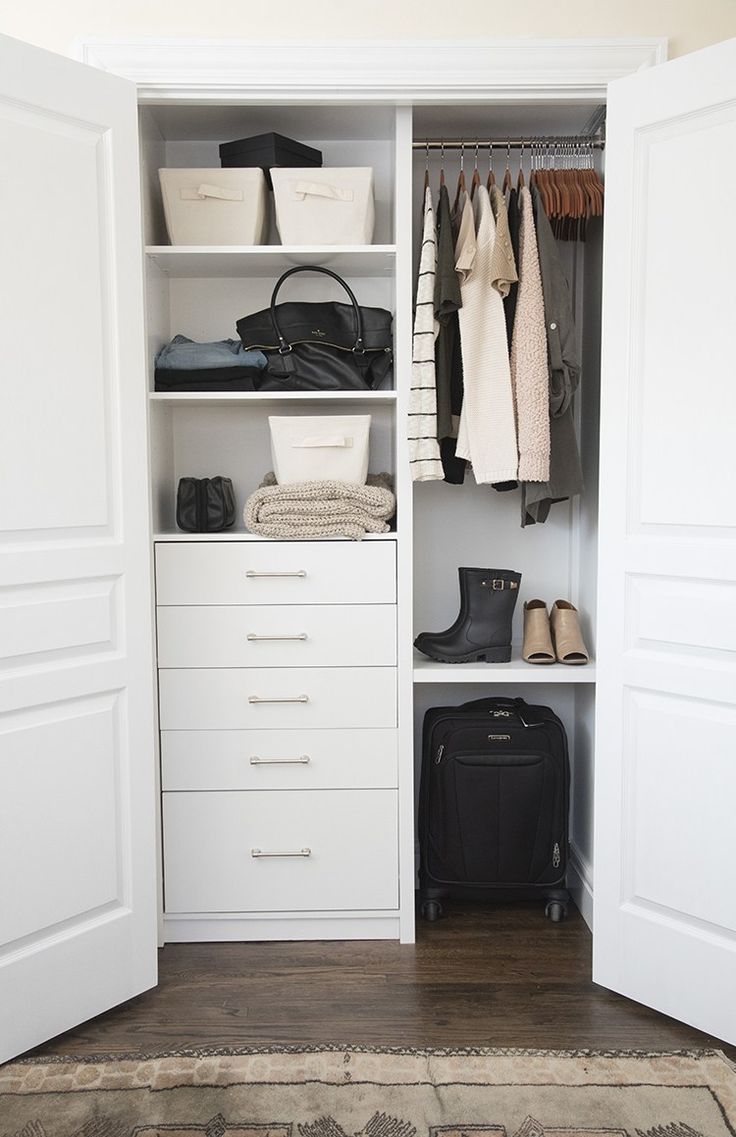 an open closet with clothes, shoes and bags