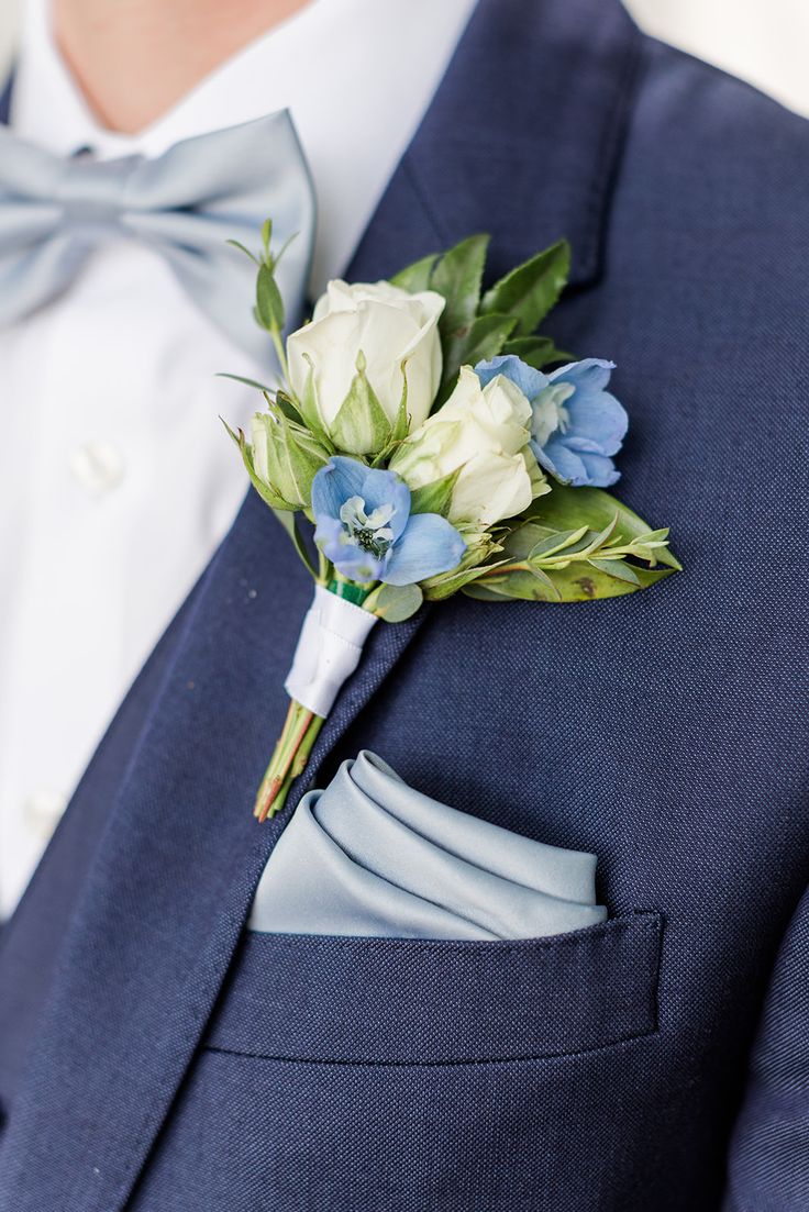 a man in a blue suit with a boutonniere on his lapel