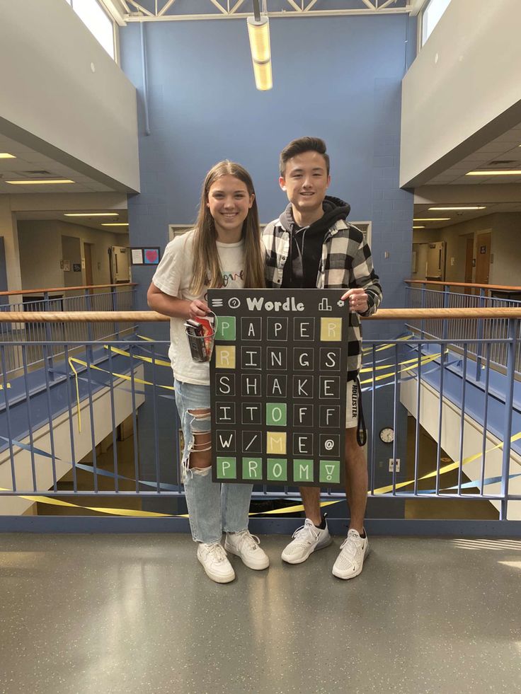 two young people standing next to each other in front of a blue and yellow wall