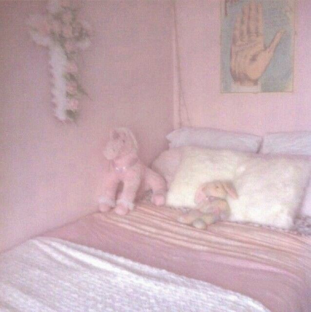 there is a stuffed animal on the bed in this pink girls'room with white sheets and pillows