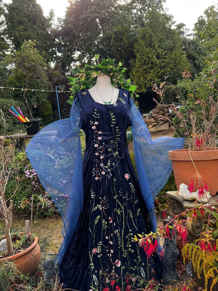 a blue dress with flowers on it in a garden