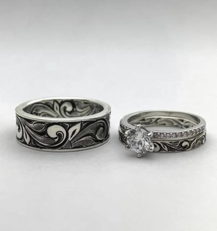 two wedding rings with diamonds on them sitting next to each other in front of a white background