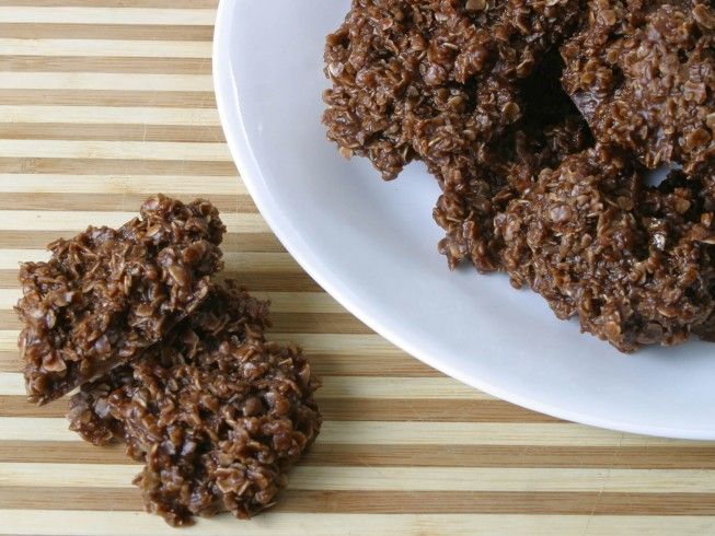 chocolate cookies on a white plate next to a wooden table