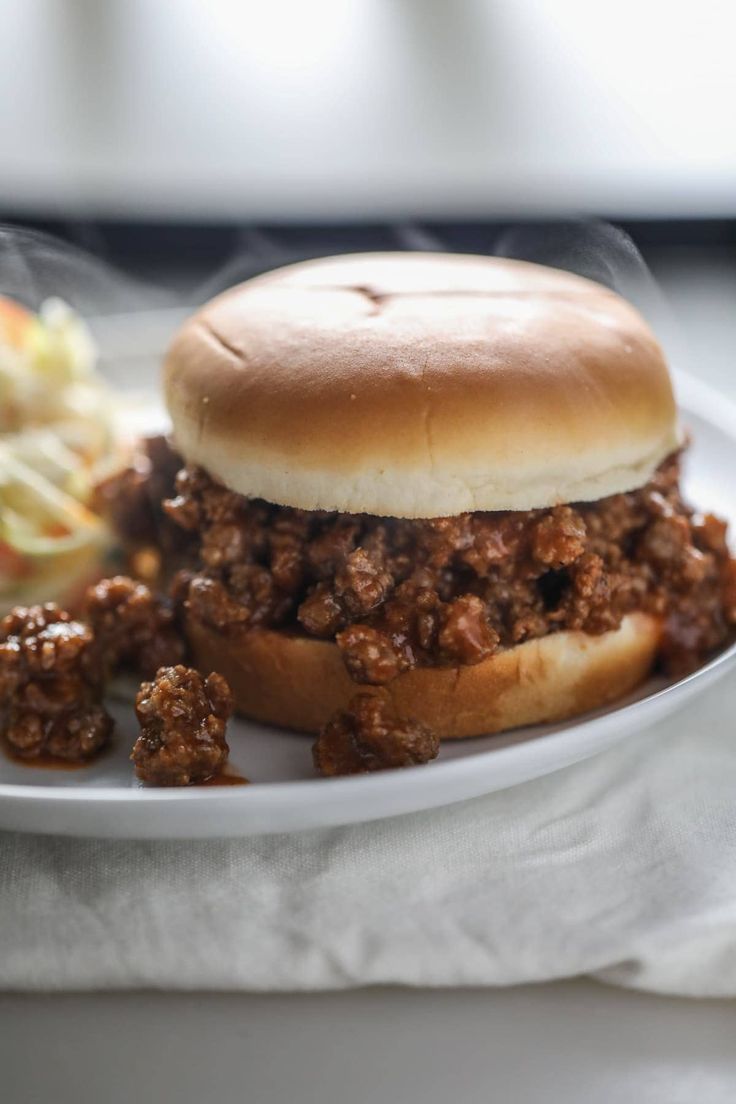 a sloppy joe sandwich on a plate with coleslaw