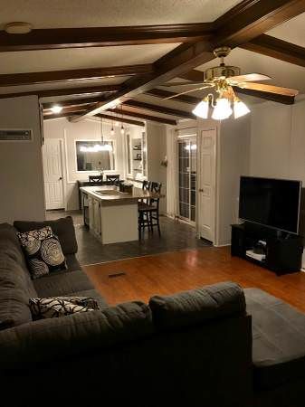 a living room filled with furniture and a flat screen tv on top of a hard wood floor