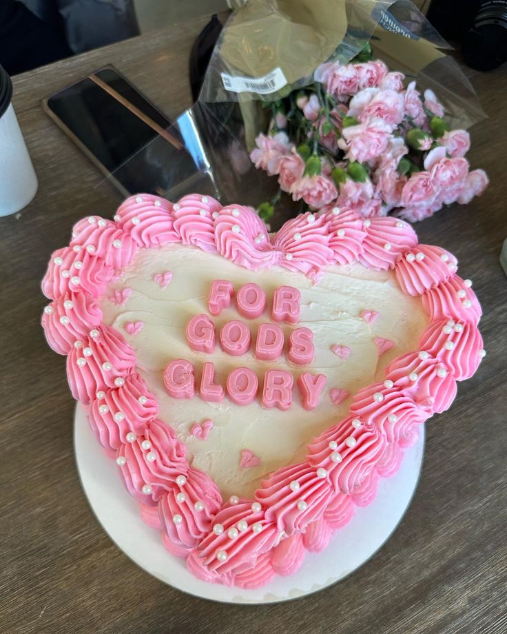 a heart shaped cake with the words for god glory written in frosting on it