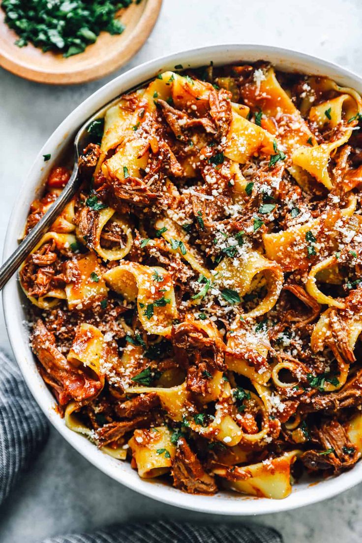 a white bowl filled with pasta and meat sauce