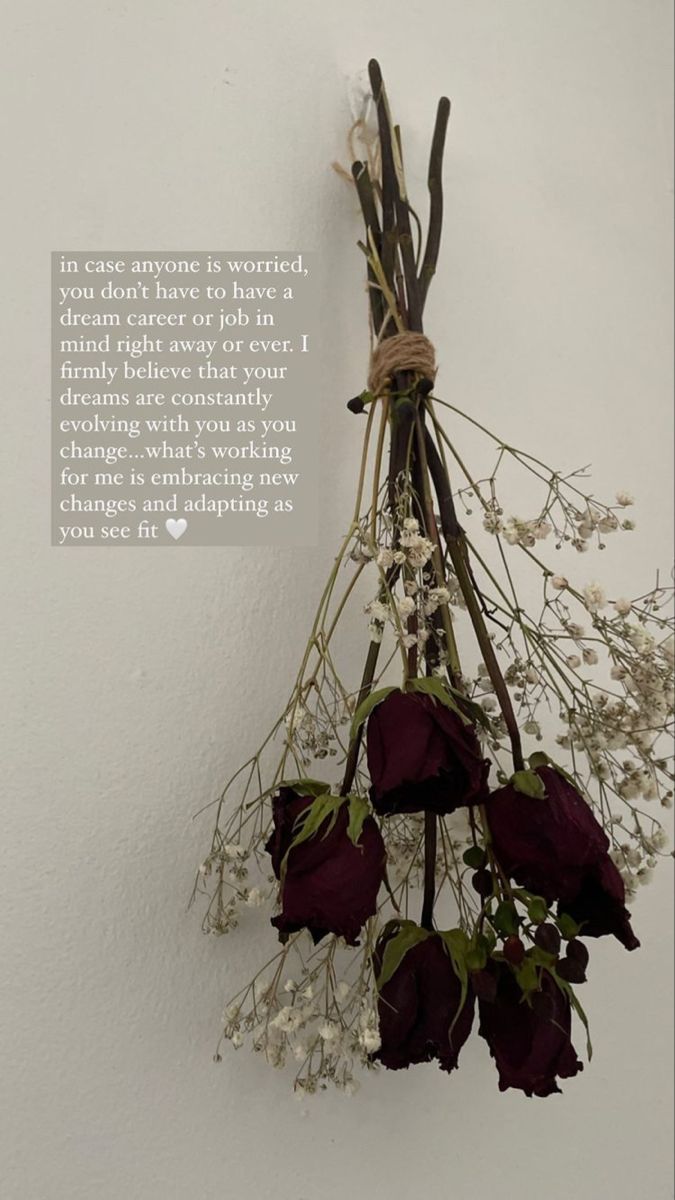 a bunch of flowers hanging from the side of a wall with a quote on it