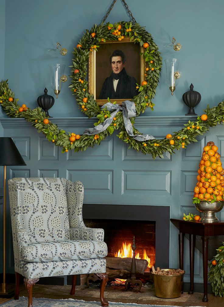 a living room decorated for christmas with oranges and wreaths on the fireplace mantel