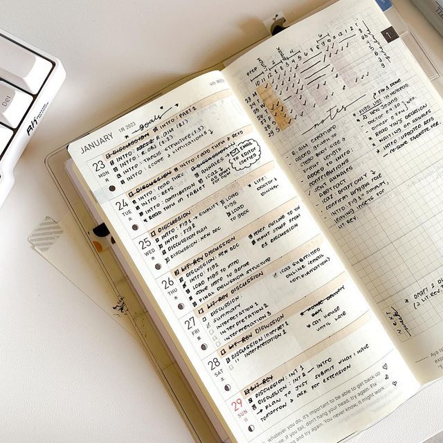 an open notebook sitting on top of a desk next to a calculator and keyboard