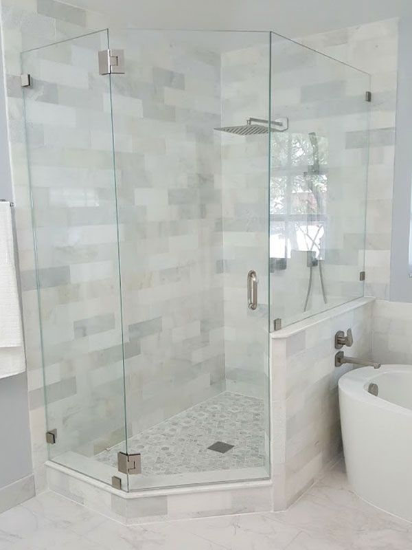 a white bath tub sitting next to a walk in shower