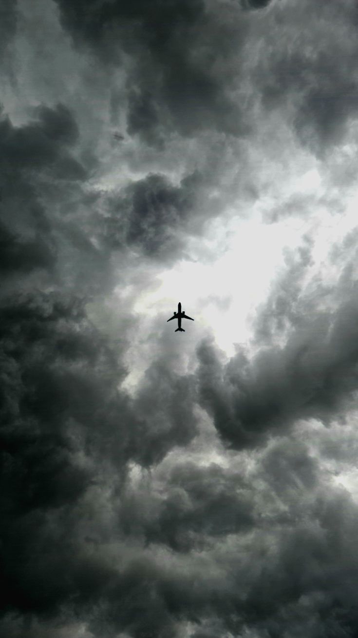 an airplane is flying in the cloudy sky