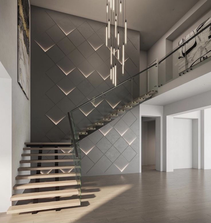 a modern staircase with glass railings and chandelier in an empty room next to a large clock