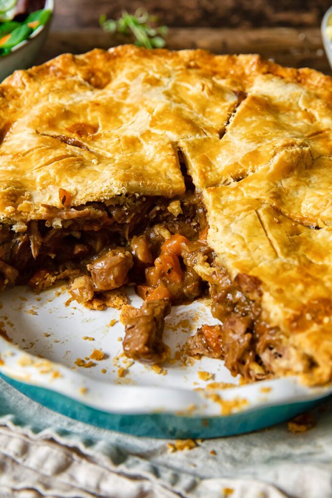 a meat pie is cut in half on a plate