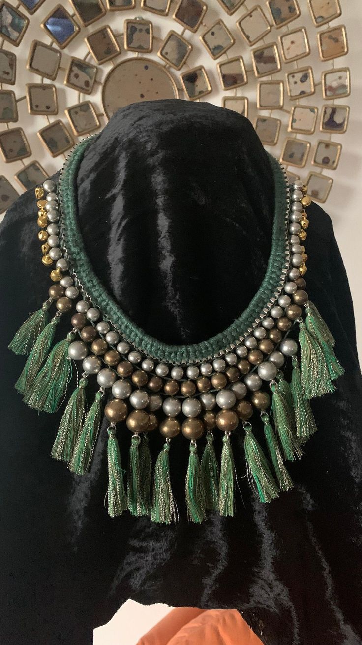 Complement your personality with this boho-chic trendy unique necklace. Our skilled Indian craftsmen beautifully handcraft the gorgeous necklace with green threads, and silver and gold beads weaved together to make a stunning piece. Light weight necklace Drop length of necklace: approximately 9 inches Comes with a lobster claw closure Adjustable Length Silver Bohemian Tassel Necklace For Party, Green Artisan Necklace For Festive Occasion, Festive Green Artisan Necklace, Bohemian Beaded Necklaces With Tassels, Handmade Hippie Green Beaded Necklaces, Handmade Green Bohemian Beaded Necklaces, Green Macrame Necklace For Festivals, Green Macrame Jewelry For Festival, Green Macrame Jewelry For Festivals