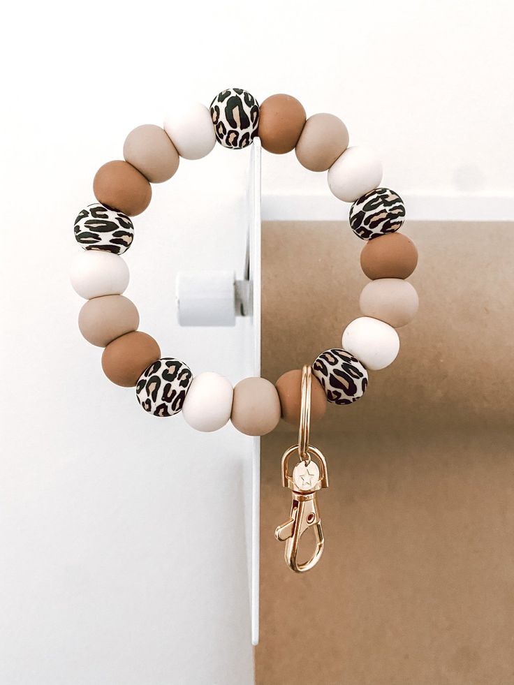 a close up of a bracelet on a door with an animal print keychain