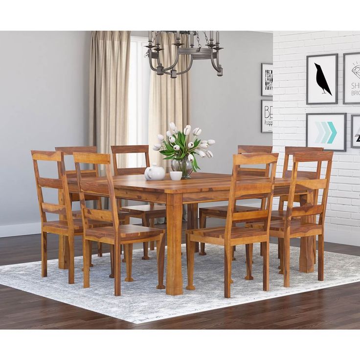 a dining room table and chairs in front of a white brick wall