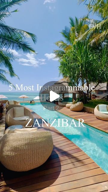 an outdoor swimming pool with lounge chairs and palm trees in front of the beach house