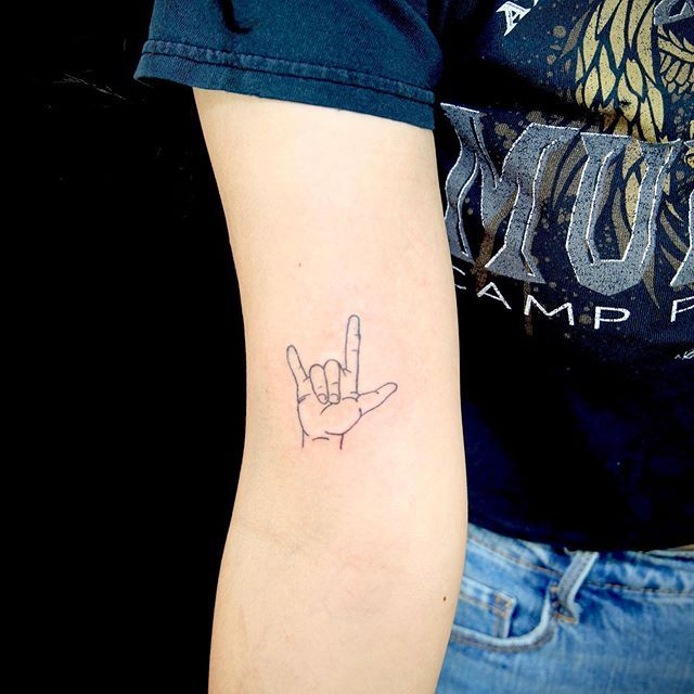 a person's arm with a tattoo on it that has a hand in the shape of a peace sign