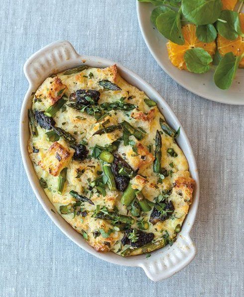 a casserole dish with spinach and cheese in it next to a plate of oranges