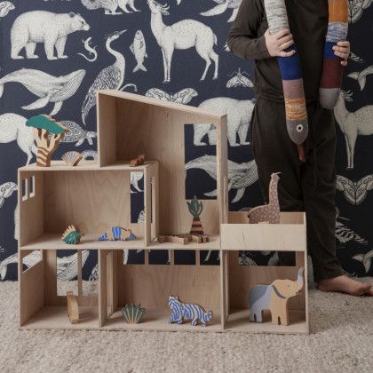 a child standing in front of a wallpaper with animals and other toys on it