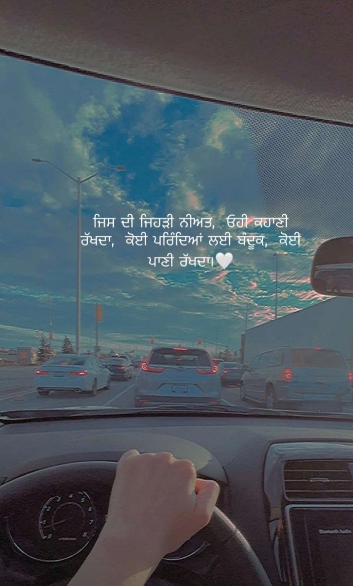 a person driving a car on a highway with cars in the background and a sky filled with clouds