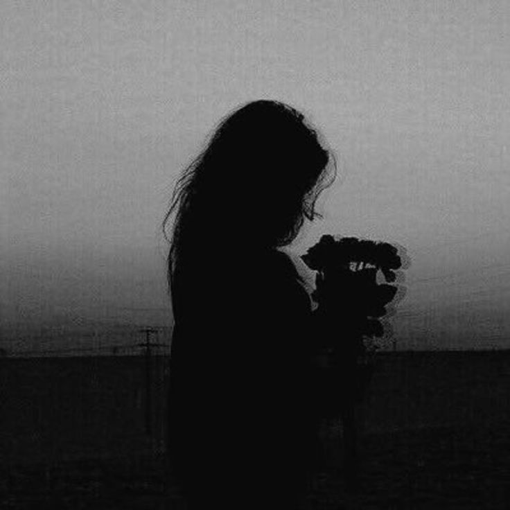 the silhouette of a woman holding flowers in her hands