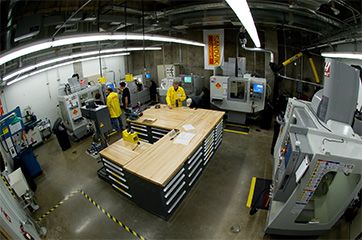 several people working in a factory with machines